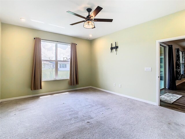 empty room featuring ceiling fan and carpet