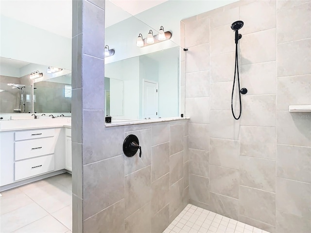full bathroom featuring tile patterned floors, tiled shower, and vanity