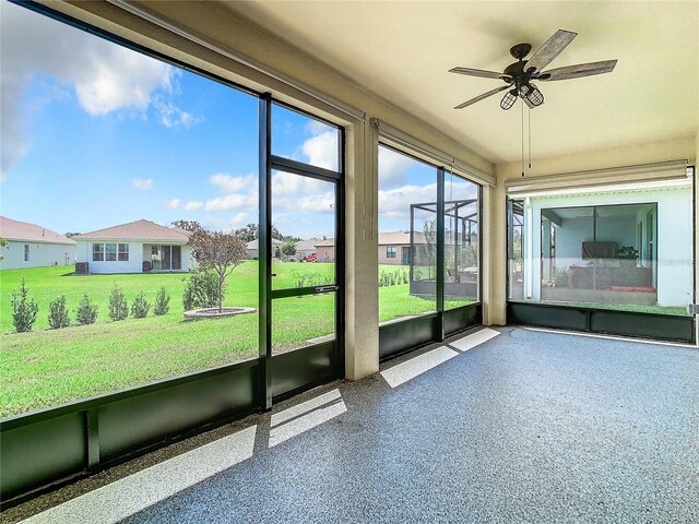 unfurnished sunroom featuring ceiling fan