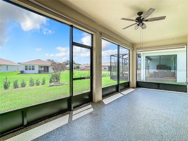 unfurnished sunroom with ceiling fan