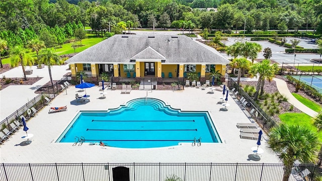 pool with a patio area and fence
