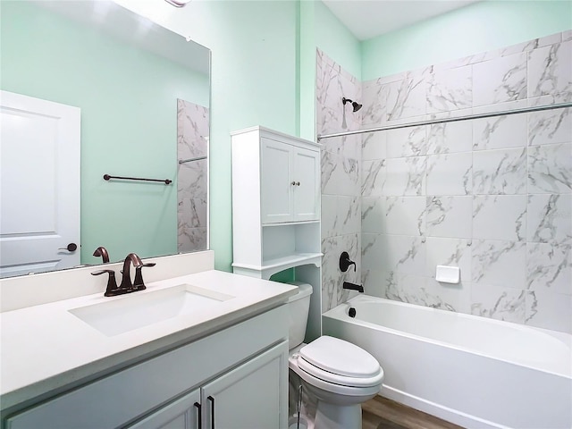 full bathroom with vanity, tiled shower / bath, wood-type flooring, and toilet