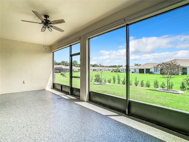 unfurnished sunroom featuring ceiling fan