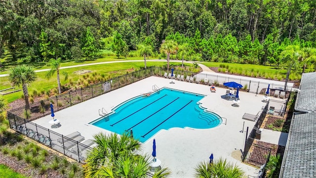 view of swimming pool featuring a lawn and a patio