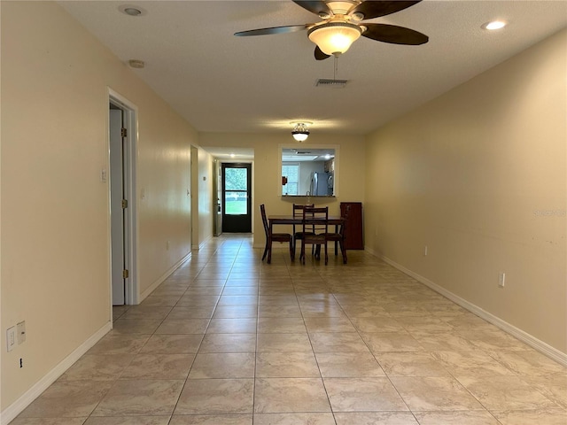 dining space featuring a textured ceiling, ceiling fan, and light tile patterned floors