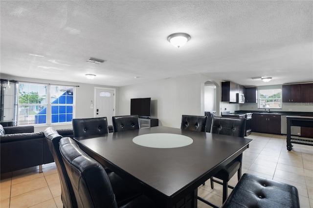 tiled dining room featuring a textured ceiling