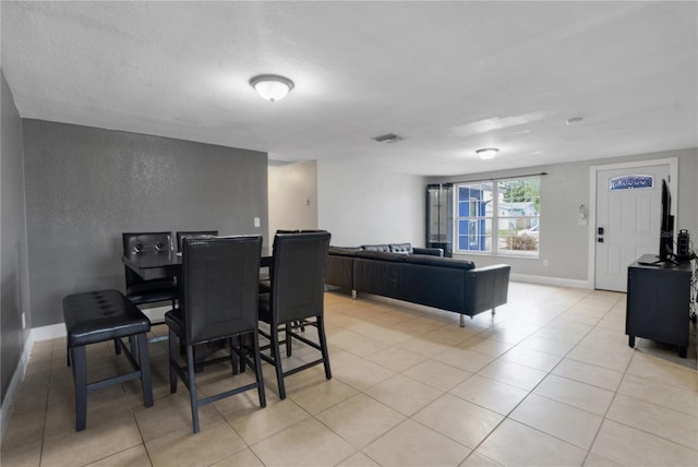 dining area featuring light tile patterned flooring and a textured ceiling