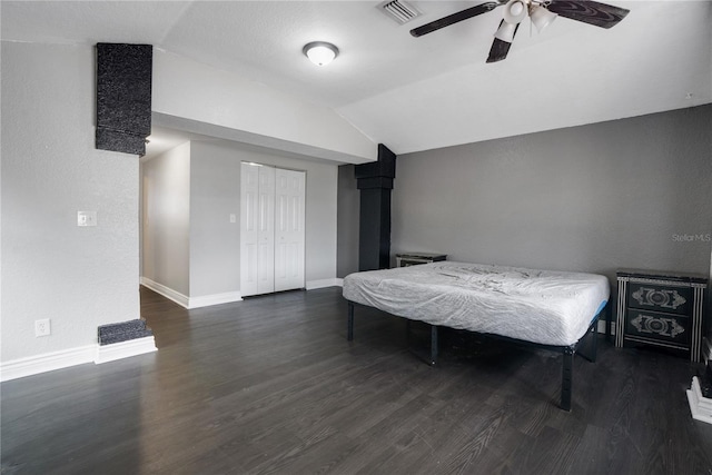 bedroom with ceiling fan, a closet, dark wood-type flooring, and vaulted ceiling