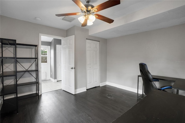 unfurnished office featuring ceiling fan and dark wood-type flooring