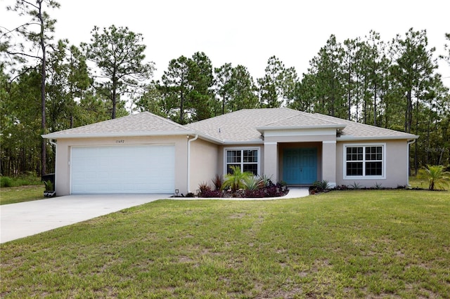 view of front facade with a garage, driveway, roof with shingles, a front yard, and stucco siding