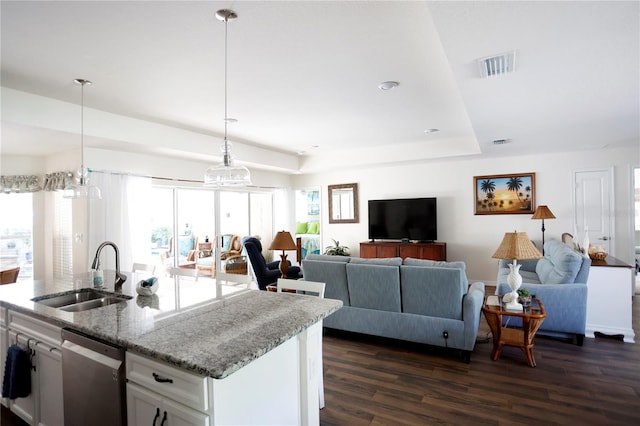 kitchen featuring an inviting chandelier, dark hardwood / wood-style floors, stainless steel dishwasher, sink, and white cabinetry