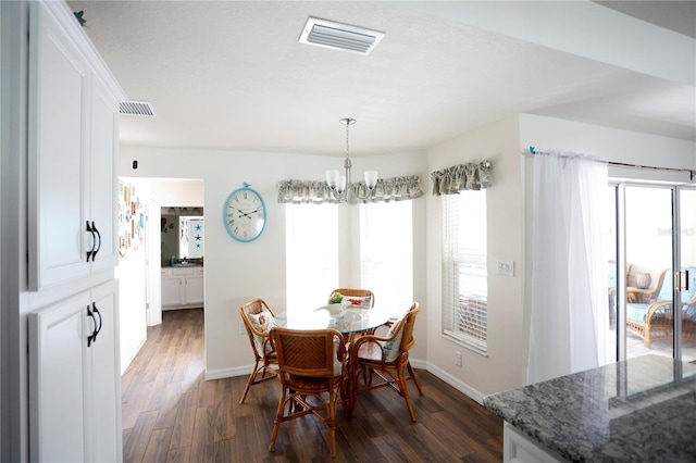 dining space with an inviting chandelier and dark hardwood / wood-style flooring