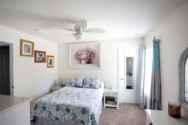 carpeted bedroom with ceiling fan and a textured ceiling