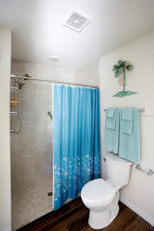 bathroom featuring wood-type flooring, toilet, and walk in shower