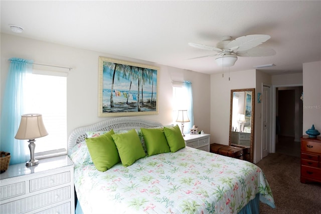 bedroom featuring multiple windows, dark carpet, and ceiling fan