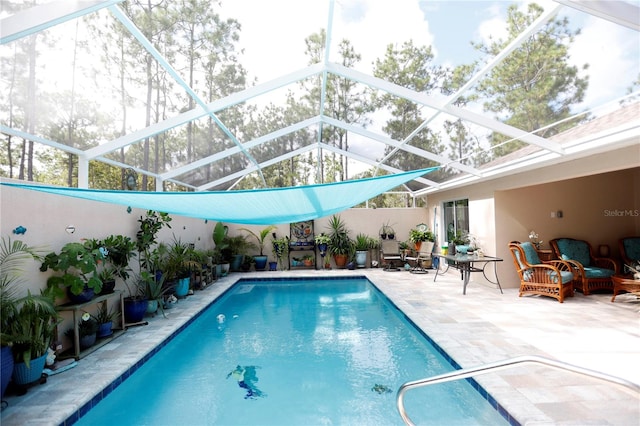 view of swimming pool featuring a lanai and a patio