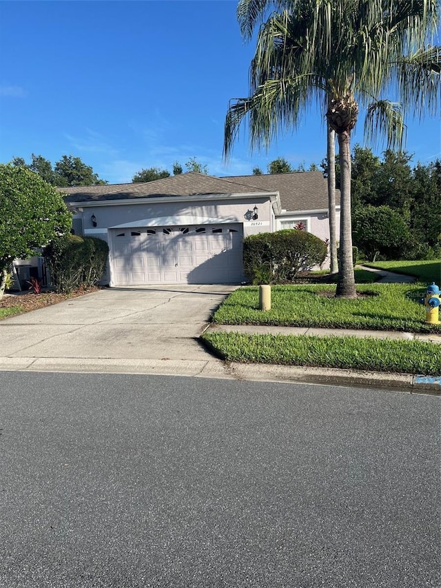 single story home featuring stucco siding, concrete driveway, and a garage