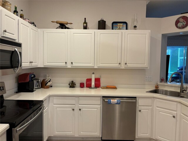 kitchen featuring sink, appliances with stainless steel finishes, and white cabinets