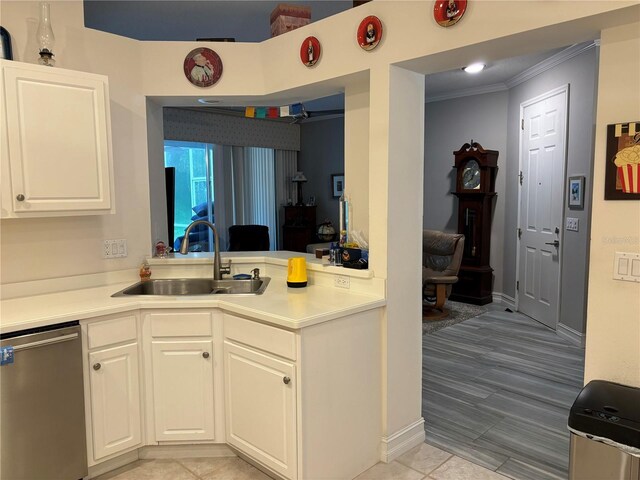 kitchen featuring crown molding, stainless steel dishwasher, sink, and white cabinetry