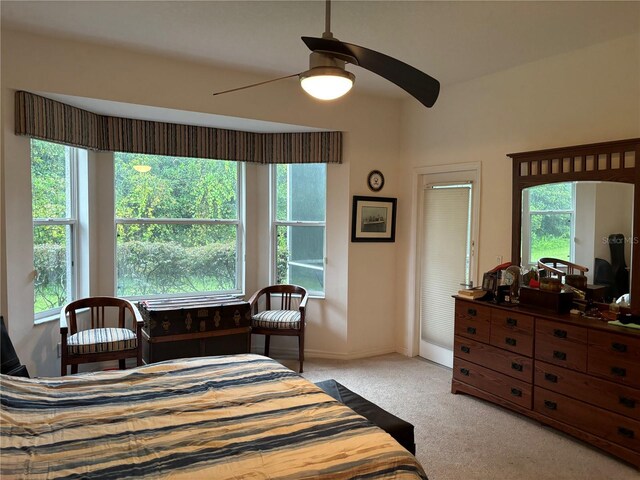 carpeted bedroom featuring multiple windows and ceiling fan