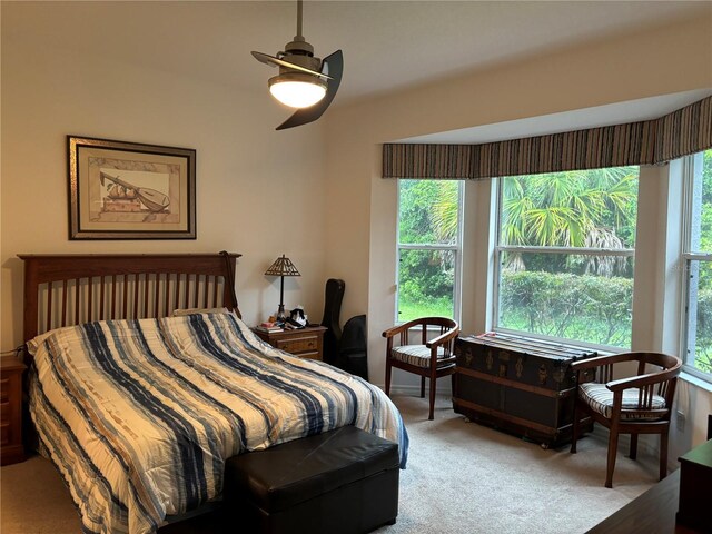 carpeted bedroom featuring multiple windows and ceiling fan