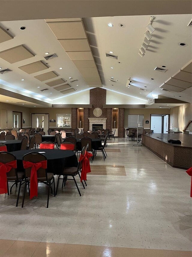 dining space with a fireplace and lofted ceiling