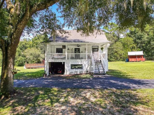 view of front of house with a porch, a shed, and a front yard