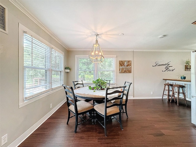 dining area featuring ornamental molding, dark hardwood / wood-style flooring, and an inviting chandelier