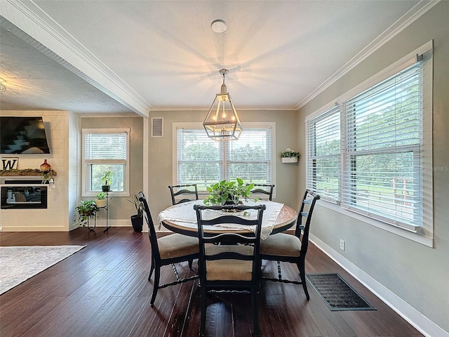 dining area with dark hardwood / wood-style floors, a chandelier, and crown molding