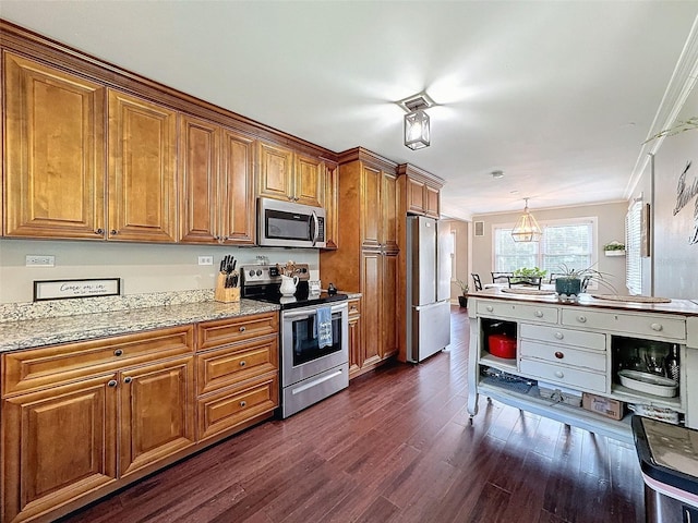 kitchen with dark wood-type flooring, appliances with stainless steel finishes, light stone countertops, and crown molding