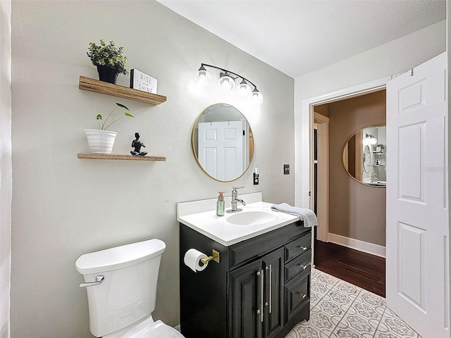 bathroom featuring vanity, toilet, and wood-type flooring