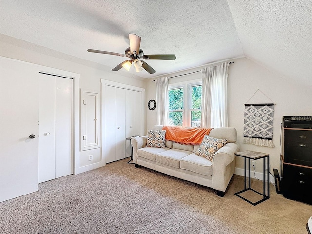 carpeted living room featuring lofted ceiling, ceiling fan, and a textured ceiling