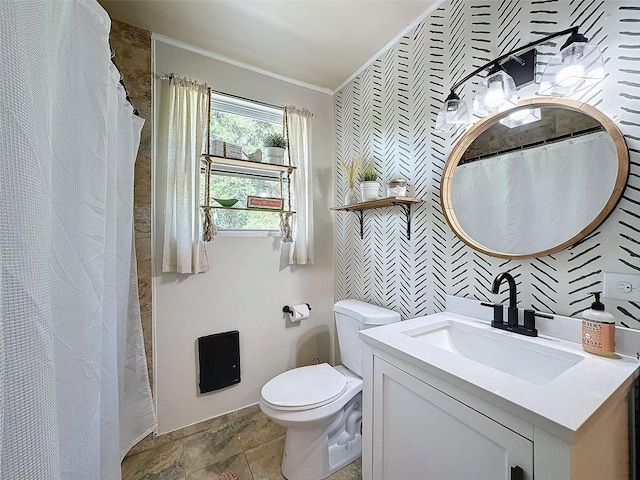 bathroom featuring toilet, ornamental molding, and vanity