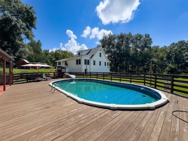 view of pool with a lawn and a deck