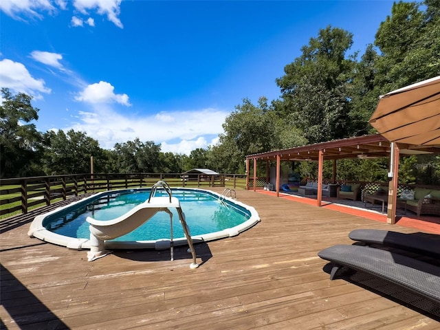 view of swimming pool with an outdoor living space and a wooden deck