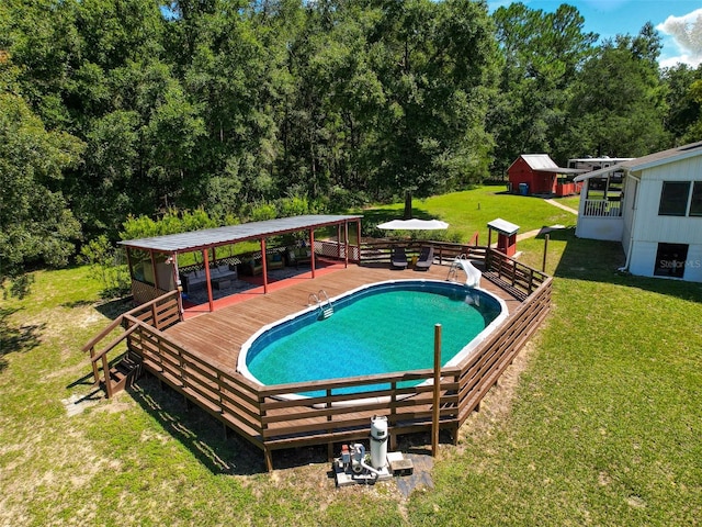 view of swimming pool featuring a storage shed, a yard, and a wooden deck