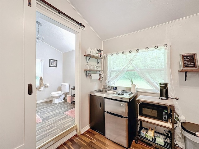 interior space featuring ornamental molding, vaulted ceiling, hardwood / wood-style flooring, and sink