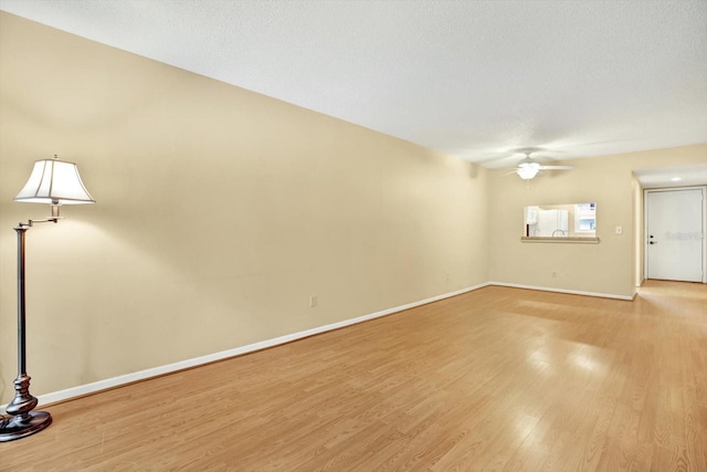 unfurnished room featuring light wood-type flooring, a textured ceiling, and ceiling fan