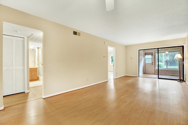 unfurnished room featuring a textured ceiling and light hardwood / wood-style flooring