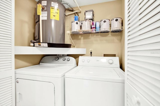 clothes washing area with separate washer and dryer and water heater