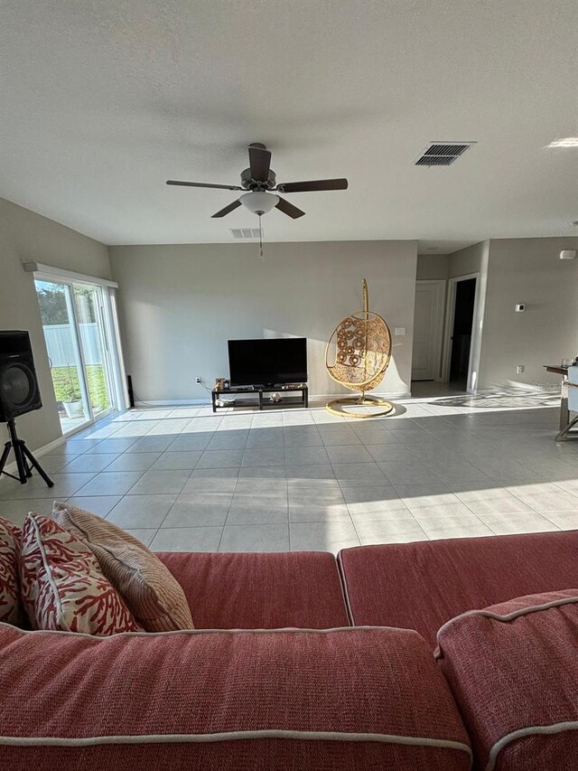 tiled living room featuring ceiling fan and a textured ceiling