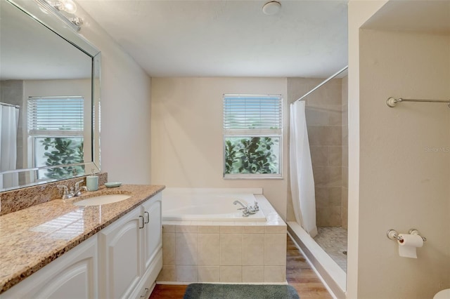 bathroom with wood-type flooring, a wealth of natural light, and independent shower and bath