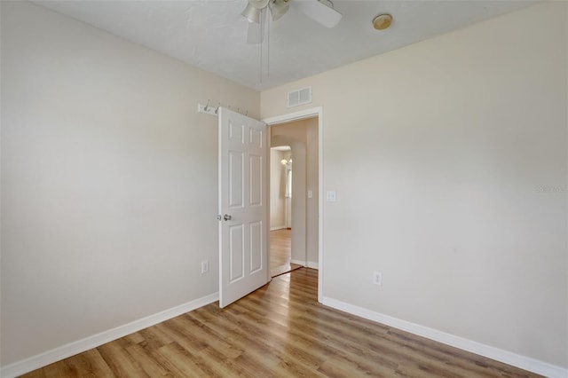 empty room with ceiling fan and light hardwood / wood-style flooring