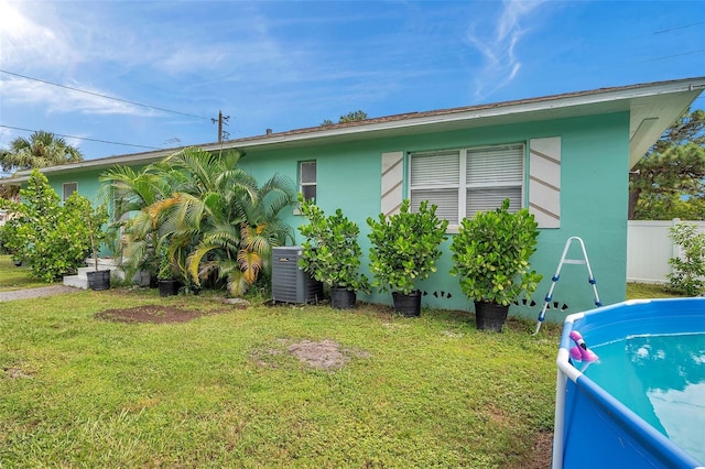 view of side of property featuring central AC and a yard