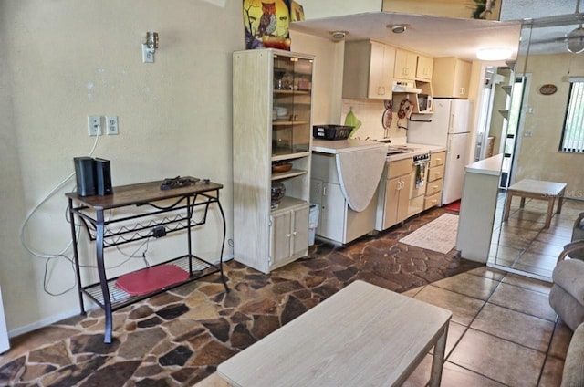 kitchen with dark tile patterned flooring and white fridge