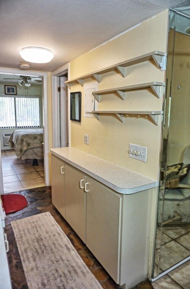 kitchen featuring ceiling fan and a textured ceiling