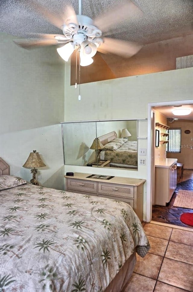 tiled bedroom with ceiling fan and a textured ceiling