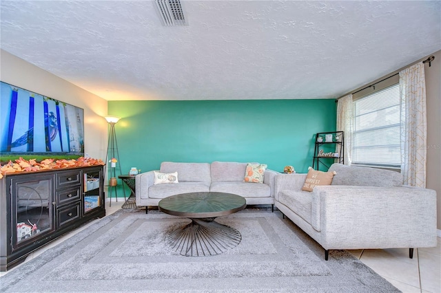 tiled living room featuring a textured ceiling