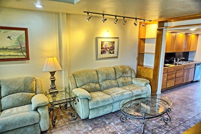 tiled living room featuring a textured ceiling, sink, and track lighting