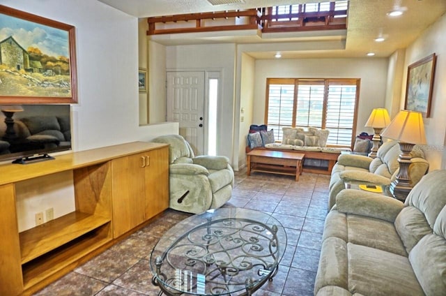 tiled living room featuring a textured ceiling